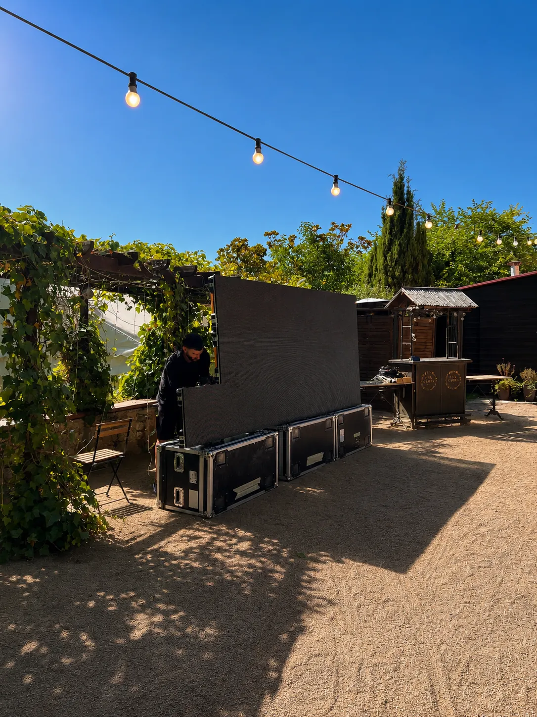 Montaje de día de la pantalla LED modular sobre flight cases en el patio de la masía de Alella