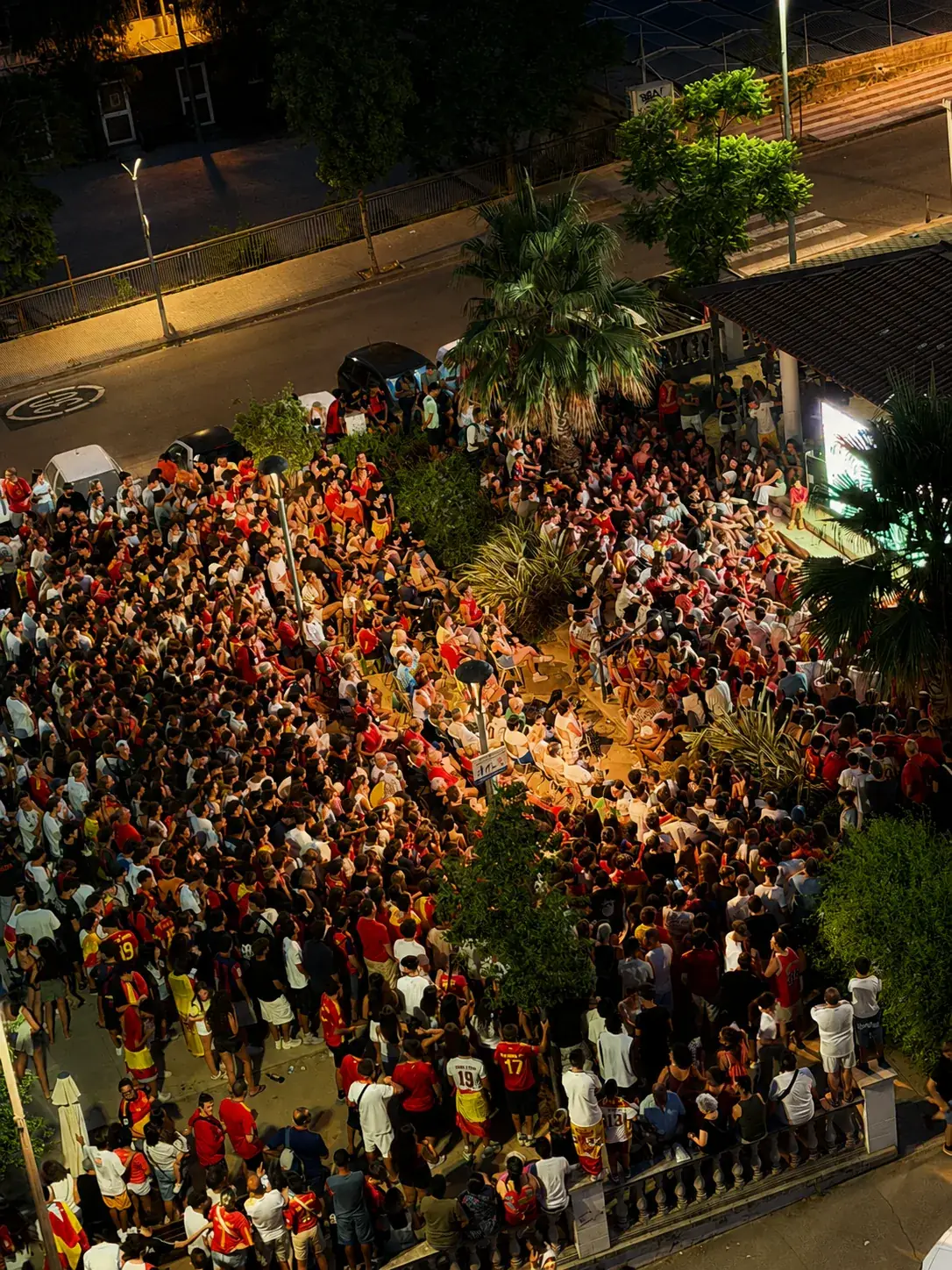 Vista aérea nocturna de la plaza llena de aficionados siguiendo la final del Mundial