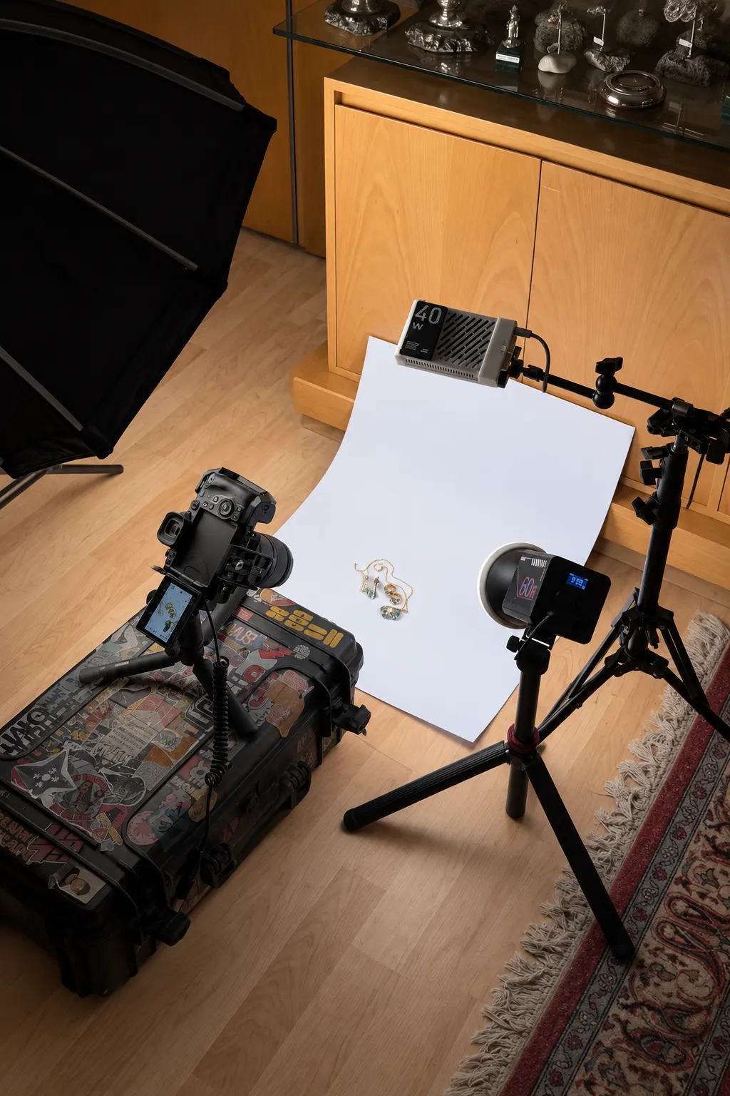Set de grabación de joyería con ciclorama blanco, cámara sobre mini trípode y dos focos LED