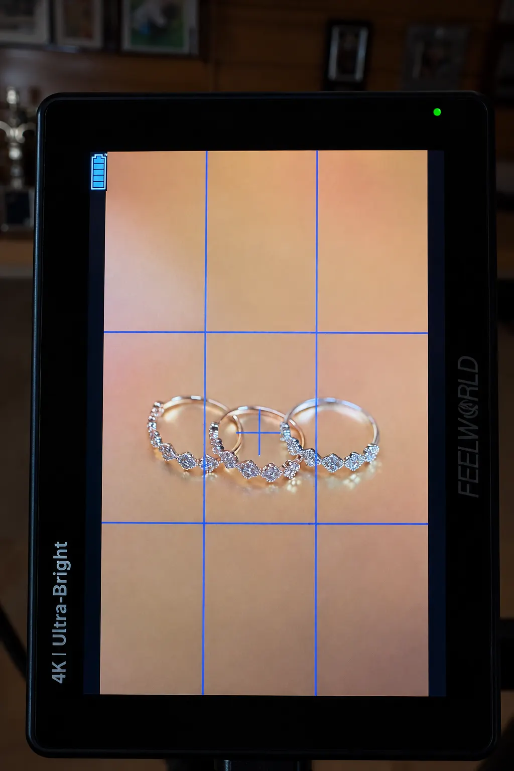 Monitor de rodaje con el plano macro de tres anillos de brillantes y la rejilla de encuadre