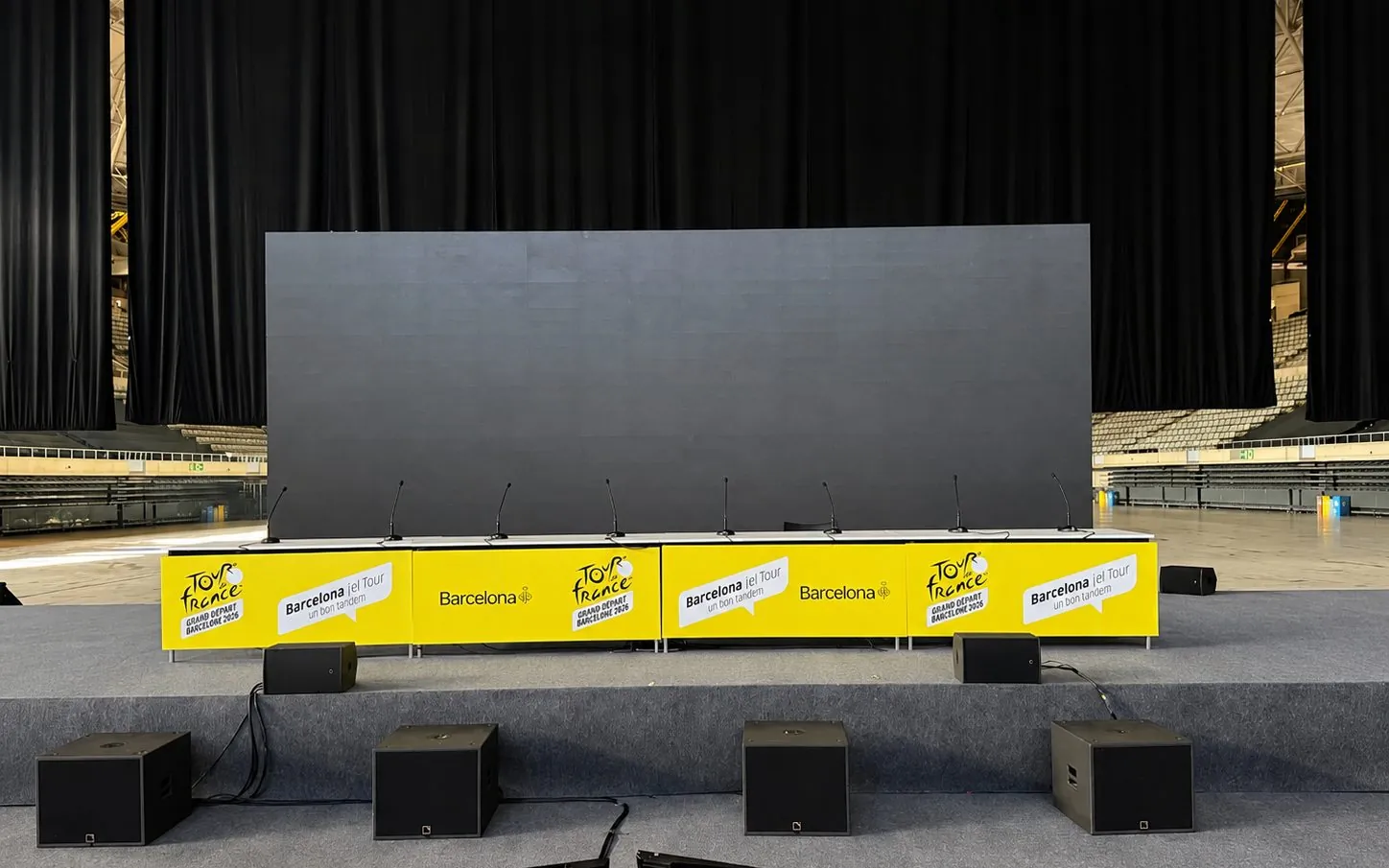 Escenario del acto con mesa presidencial, faldón amarillo del Tour de France y sistema de conferencia en el Palau Sant Jordi